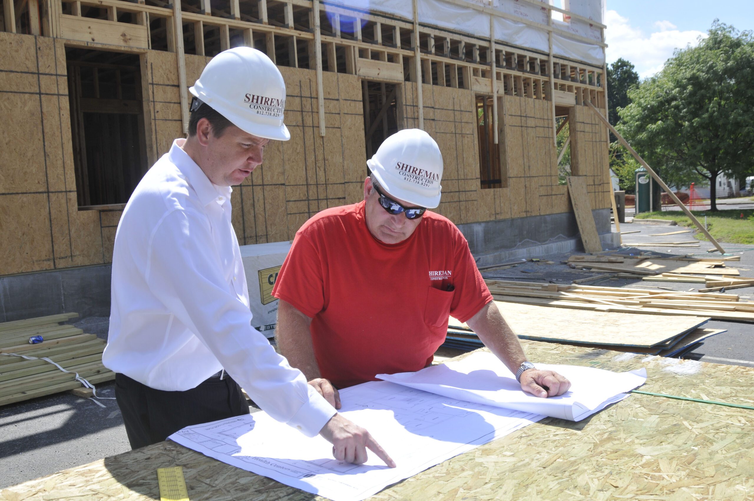 Two contractors discussing blueprints for general construction